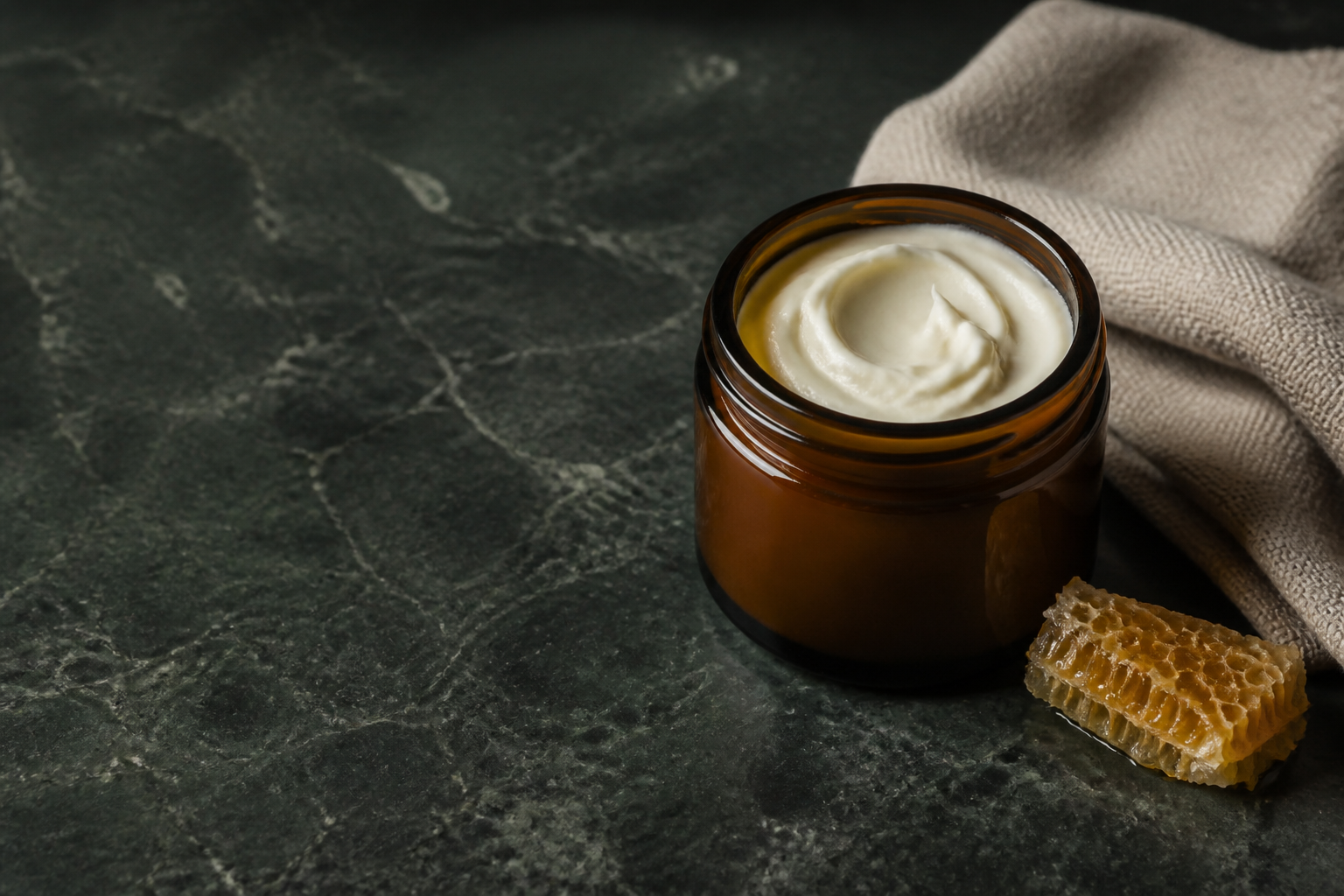 Unbranded jar of tallow face cream on green stone